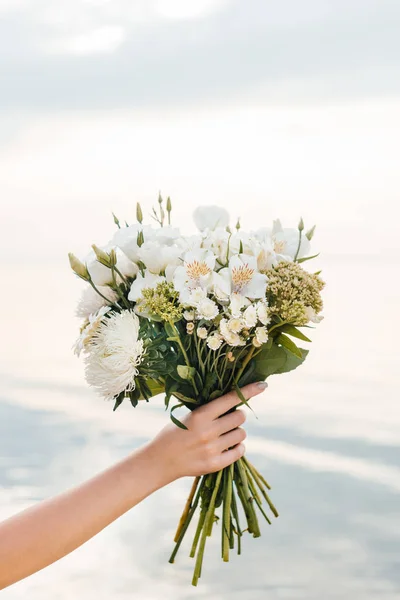 Vista recortada de la mujer sosteniendo hermoso ramo con flores blancas - foto de stock