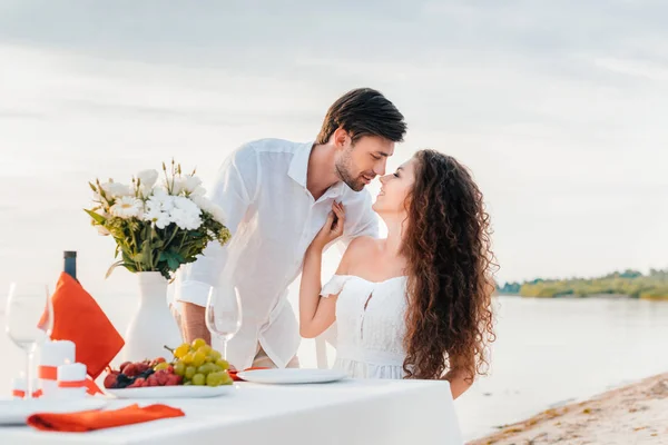 Hermosa pareja besándose en romántico fecha en la orilla del mar - foto de stock