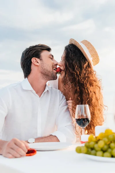 Pareja comiendo fresa juntos durante la cita romántica - foto de stock