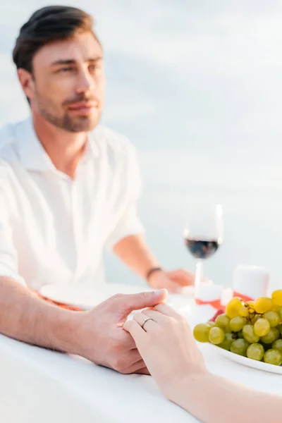 Junges Paar hält Händchen nach Heiratsantrag bei romantischem Date — Stockfoto