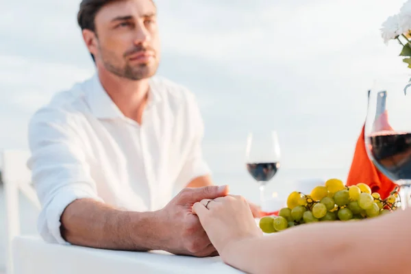 Junges Paar hält Händchen nach Heiratsantrag bei romantischem Date — Stockfoto