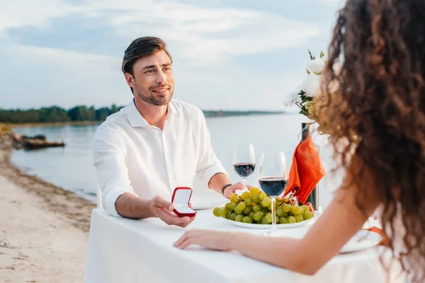 Smiling boyfriend making propose with ring to girlfriend in romantic date outdoors — Stock Photo