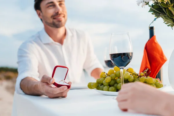 Happy man making propose with ring to girlfriend in romantic date — Stock Photo