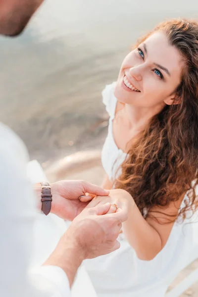 Cropped view of man wearing ring on womans finger after propose — Stock Photo