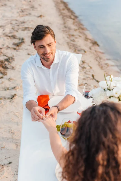Handsome man wearing ring on womans finger after propose on romantic date — Stock Photo