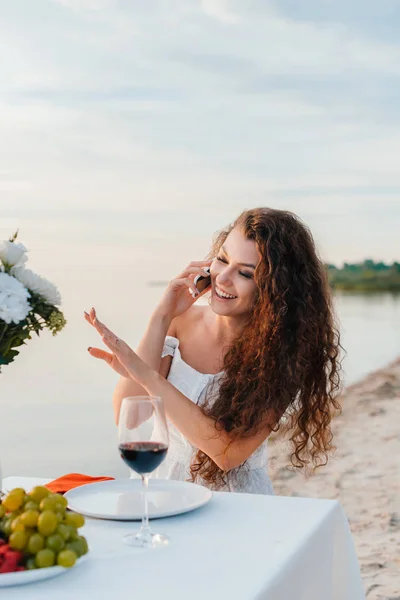 Attractive happy woman talking on smartphone and looking on engagement ring on her hand — Stock Photo