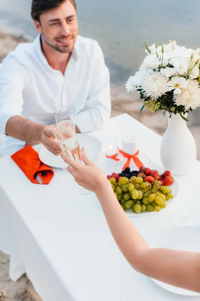 Young couple clinking with champagne glasses during romantic date — Stock Photo