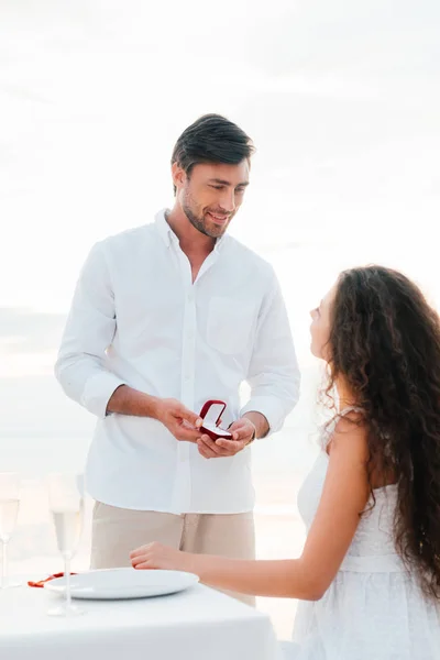 Handsome man making propose with ring to girlfriend in romantic date — Stock Photo