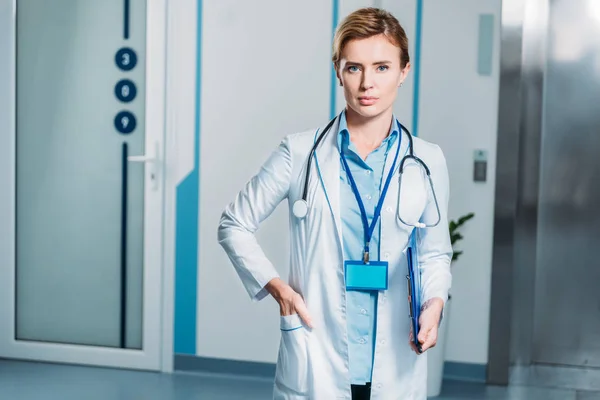 Портрет жінки-лікаря зі стетоскопом над шиєю, що тримає буфер обміну в лікарні — стокове фото