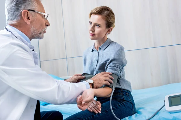 Reifer männlicher Arzt misst Druck einer Patientin mit Tonometer im Krankenhauszimmer — Stockfoto