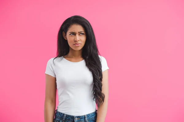 Retrato de la joven afroamericana pensativa mirando hacia otro lado aislado en rosa - foto de stock