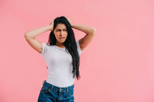 Retrato de mujer afroamericana confusa mirando hacia otro lado aislada en rosa - foto de stock