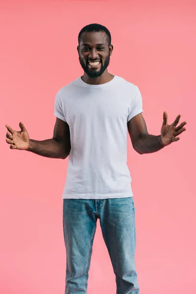 Щасливий афроамериканський чоловік з простягнутими руками ізольовано на рожевому — стокове фото