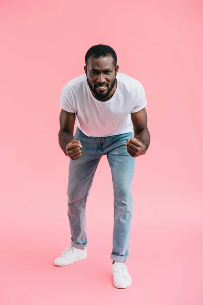 Irritado afro-americano homem mostrando punhos em rosa bakcdrop — Fotografia de Stock