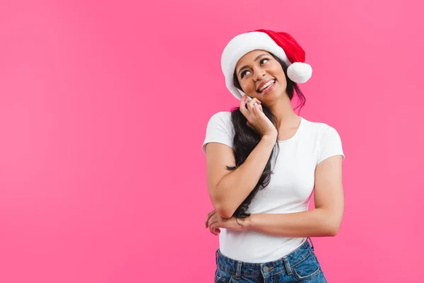 Porträt einer afrikanisch-amerikanischen Frau mit Weihnachtsmann-Hut, die auf einem Smartphone isoliert auf rosa — Stockfoto