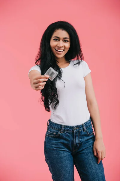 Happy young african american woman showing condom isolated on pink background — Stock Photo