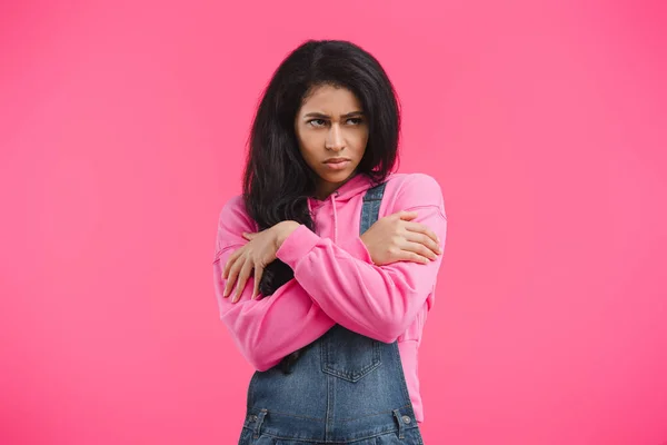 Сердитий молода жінка з схрещеними руками, ізольовані на рожевий фон — стокове фото