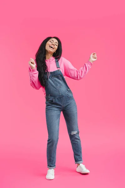 Atractiva mujer afroamericana joven con estilo bailando sobre fondo rosa - foto de stock