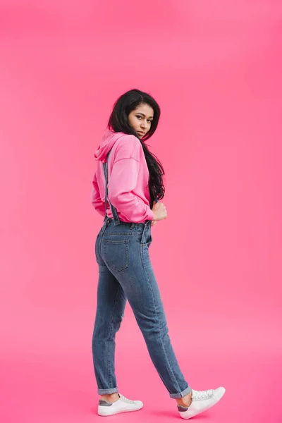 Stylish young african american woman in denim overall posing on pink background — Stock Photo