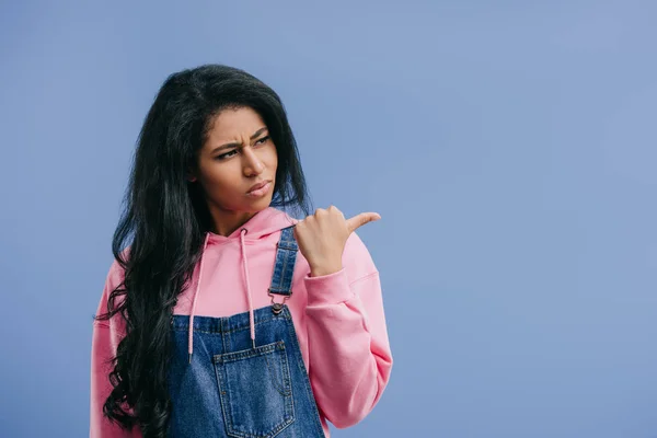 Angry young african american woman pointing aside isolated on blue background — Stock Photo