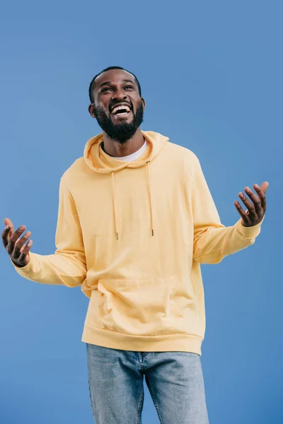 Hombre afroamericano excitado gestos por las manos aisladas sobre fondo azul - foto de stock