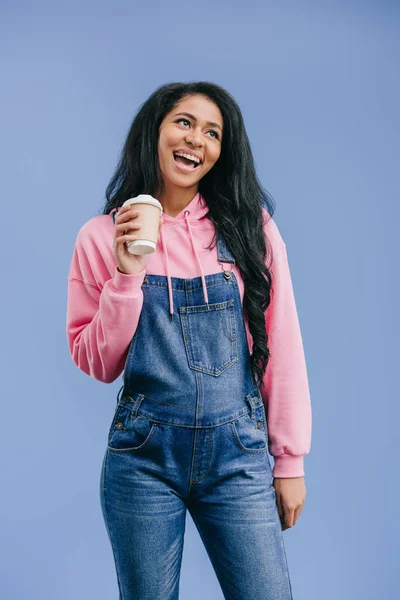 Happy african american woman with disposable coffee cup isolated on blue background — Stock Photo