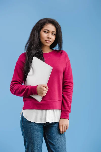 Beautiful african american woman with laptop looking at camera isolated on blue background — Stock Photo