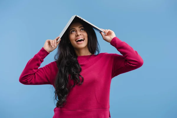 Happy african american woman holding laptop over head isolated on blue background — Stock Photo