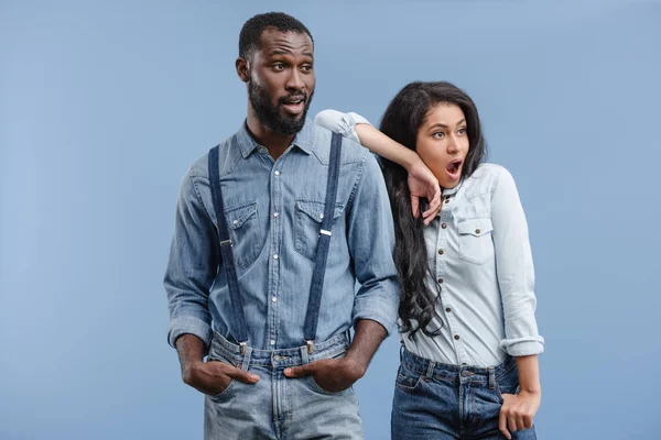 Impactó pareja afroamericana mirando hacia otro lado aislado en azul - foto de stock