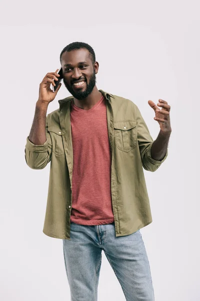 Glücklich gutaussehender afrikanisch-amerikanischer Mann, der per Smartphone spricht und isoliert auf weißem Grund gestikuliert — Stockfoto