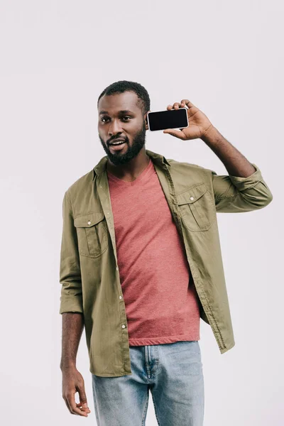 Surprised handsome african american man talking by smartphone isolated on white — Stock Photo