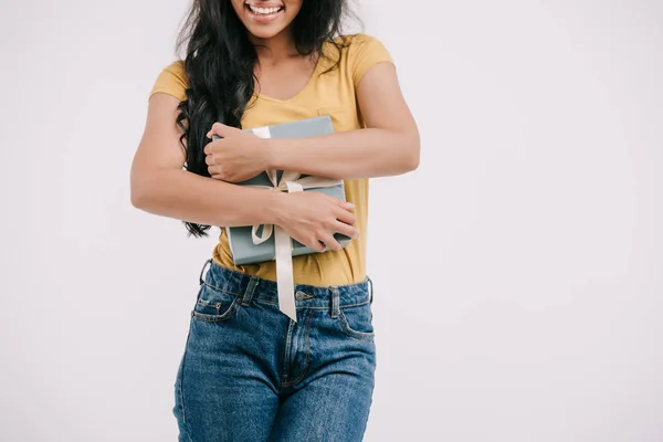 Immagine ritagliata di sorridente ragazza afro-americana abbracciando scatola presente isolato su bianco — Foto stock