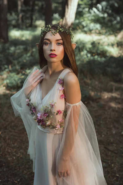 Hermoso elfo místico en elegante vestido de flores en el bosque - foto de stock