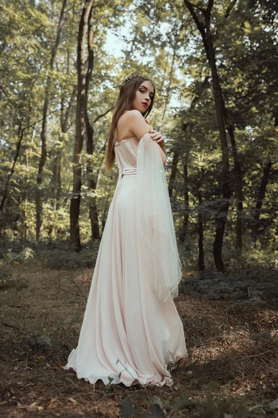 Привабливий містичний ельф позує в елегантній сукні в лісі — стокове фото