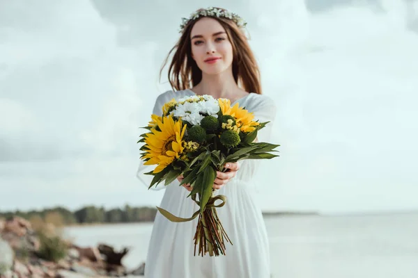 Schöne elegante Mädchen mit Blumenstrauß mit gelben Sonnenblumen — Stockfoto