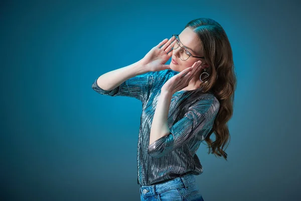 Belle femme élégante portant des lunettes et regardant loin isolé sur bleu — Photo de stock