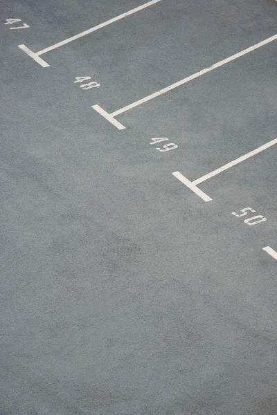 Estacionamientos vacíos con números en asfalto gris - foto de stock