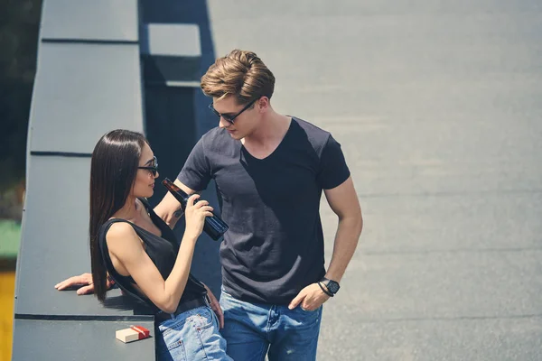 Interracial couple with cigarettes and beer spending time on roof — Stock Photo
