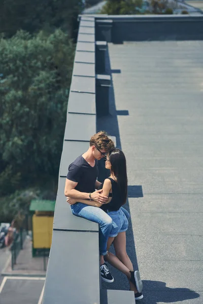 Многокультурная сексуальная пара, обнимающаяся на городской крыше — стоковое фото