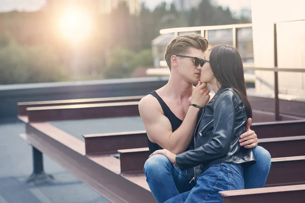 Interracial casal sexy quente beijando no telhado urbano com luz solar — Fotografia de Stock