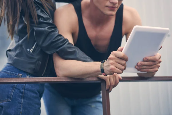 Cropped view of couple hugging and using digital tablet — Stock Photo