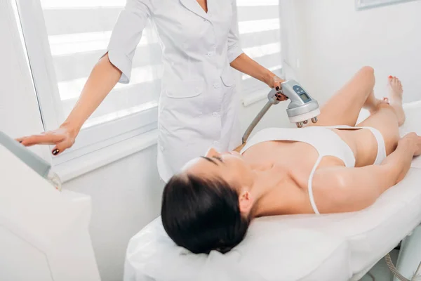 Attractive woman getting electrical massage made by cosmetologist in spa salon — Stock Photo