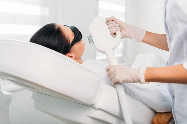 Frau mit Schutzbrille bekommt Laser-Haarentfernung von Kosmetikerin im Wellness-Salon — Stockfoto