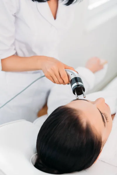 Attraente donna ottenere facciale microcurrent terapia in spa salone — Foto stock
