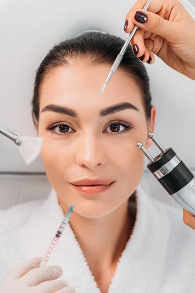 Overhead view of woman with various facial treatment equipment around in spa center — Stock Photo