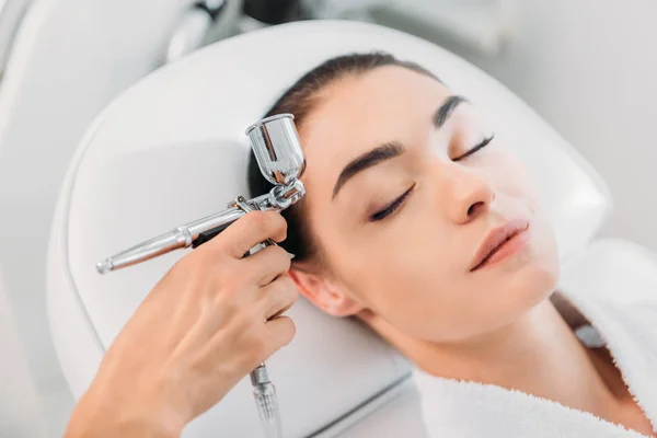 Attractive woman receiving facial treatment in spa center — Stock Photo