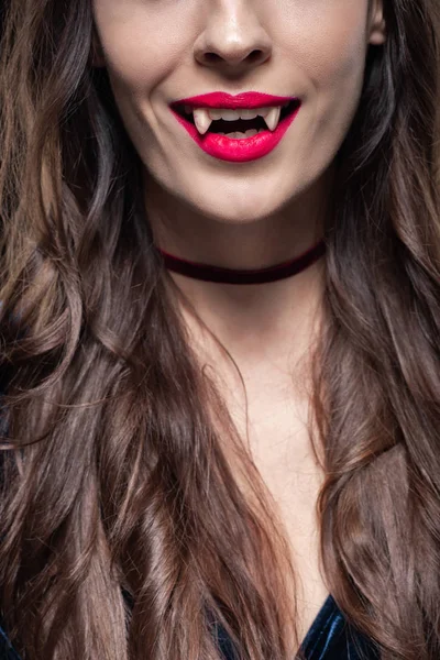 Vista recortada de la mujer mostrando colmillos de vampiro - foto de stock
