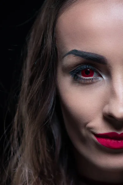 Half face portrait of vampire with red eyes isolated on black — Stock Photo