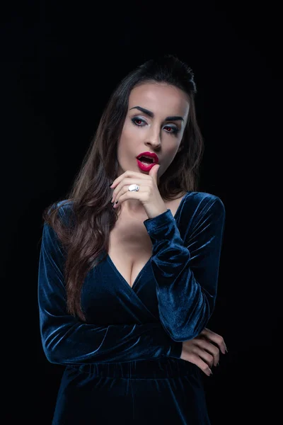 Beautiful vampire touching her lips isolated on black — Stock Photo