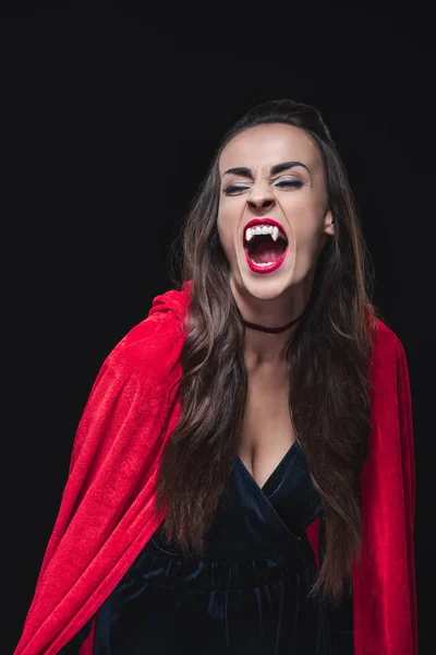 Містична вампірська жінка в червоному плащі, що показує зуби ізольовані на чорному — стокове фото